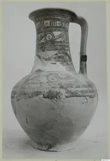 Painted jug with a strap handle and bands of decoration on the neck and shoulder