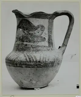Bichrome painted jug with a wavy rim, strap handle and a dark motif on the shoulder panel