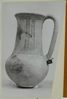Wheel-made bichrome pottery jug from Enkomi, with dark painted vertical bands on the neck and a strap handle