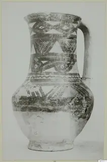 Bichrome wheel-made jug with a strap handle, dark bands and light painted triangles on the upper body