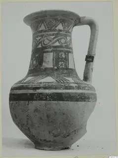 Painted jug with a curved handle, decorated with bands of triangles, scrolls and hatched panels in dark paint.