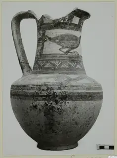 Bichrome wheel-made pottery jug with a strap handle and painted bands, with a bird-like motif on the neck