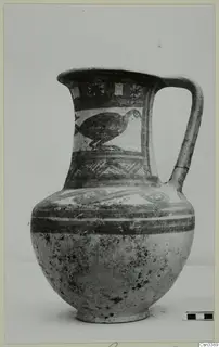 Bichrome wheel-made jug with a painted bird and bands of ornament.