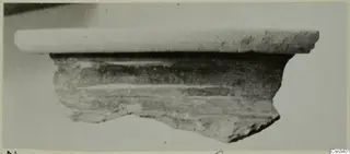 Rim and body fragment of a wheel-made pottery vessel, photographed against a plain background.