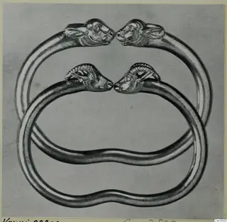 Two bracelets with animal-head terminals facing each other, interlocked, shown against a grey background.