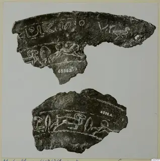 Two fragments of a dark, corroded bowl with incised animal and bird figures and letter-like signs