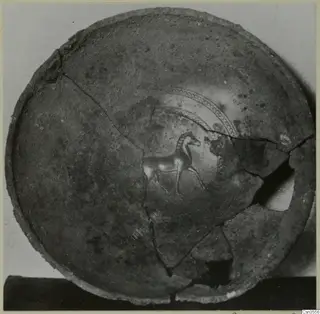 Interior of a broken and mended round bowl with a small painted animal figure and dotted concentric arcs.