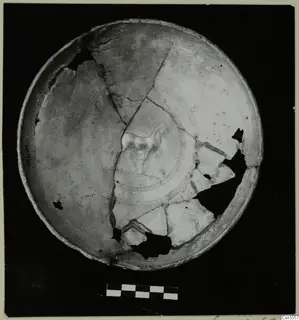 Broken bowl reconstructed from sherds, with a painted horse and concentric dotted rings on its inner surface