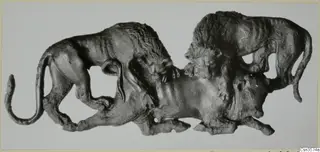Bronze relief of two lions attacking a bull, shown against a pale background.
