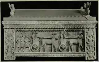 Sarcophagus front carved in relief with walking figures, a two-wheeled cart and two animals in harness.