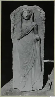 Limestone relief of a standing veiled woman in an arched slab, shown with a scale rod beside it