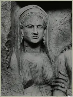 Carved stone relief of a woman's head and upper body, with wavy hair under a veil and a visible earring