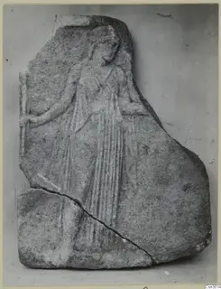 Relief fragment of a standing figure in a long pleated garment on a grey stone plaque