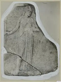 Marble relief plaque showing a standing figure in long, folded drapery, with a diagonal crack across the lower slab