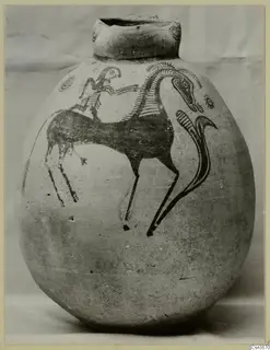 Round painted jug with a dark figure seated on a long-necked animal, photographed against a pale backdrop.