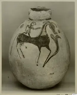 Painted jug with a rider on a long-necked animal in dark paint on a pale ground
