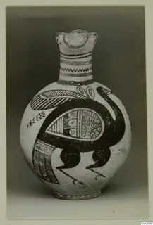 Painted jug with a modelled head at the top of the neck and a large dark bird painted on the body