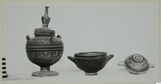 Three painted pottery vessels: a tall lidded vessel with a spout, a plain two-handled bowl, and a low two-handled lidded pot.
