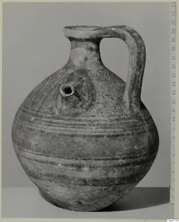 Pottery Bichrome V: a globular jug with a strap handle and a small tubular spout, shown with a scale ruler