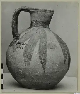 Bichrome V painted jug with a strap handle and long tapering dark bands on a pale body.