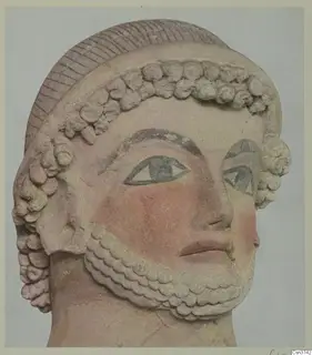 Head from a terracotta sculpture from Mersinaki, with rows of curls, a ridged cap and painted eyes and cheeks