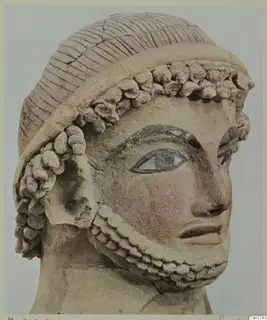 Terracotta head from Mersinaki with a ridged cap, rows of curls and a curled beard, eyes and brows painted dark