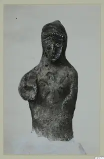 Terracotta figurine of a bust with a head covering and traces of blue and white paint