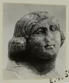 Stone statue head from Arsos, shown in three-quarter view with wavy hair and a weathered surface