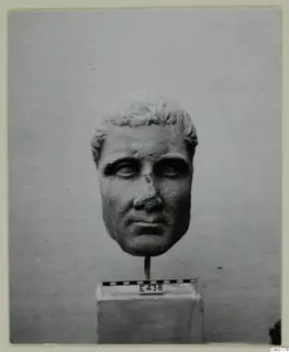 Roman sculpture: stone head of a man on a rod above a square base, with a scale bar and number label