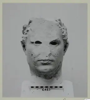 Marble head of a male figure with curled hair, eyes hollowed out, mounted on a plinth