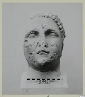 Head of a statue in stone, shown frontally on a base with a scale bar.