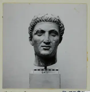 Hellenistic and Roman sculpture: carved stone head with curled hair, shown on a stand with a scale bar and label E475