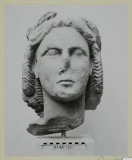 Marble head of a young woman with wavy hair swept back, shown on a stand with a scale bar.