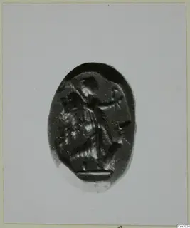 Oval dark stone gem engraved with a figure in profile facing right, shown on a light card