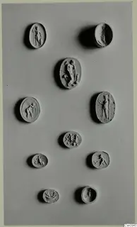 Ten oval seals and gems with engraved or carved figures and animals, arranged on a grey board.