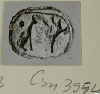 Oval seal or gem with an engraved design of dark lines, photographed on a grey card mount