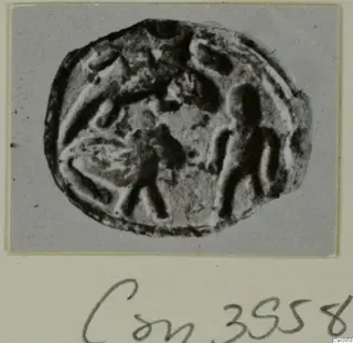 Oval seal or gem with carved figures, shown in a photograph mounted on a grey card