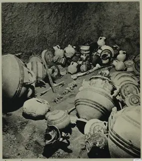Pottery vessels and bone fragments lying together on the floor of a pit, Lapithos