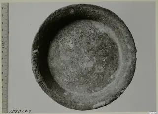 Shallow bowl with a thick rim, photographed from above beside a ruler for scale