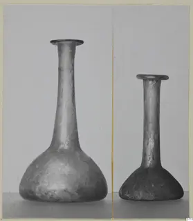 Two blown glass bottles with long necks and flared rims, one noticeably larger than the other.