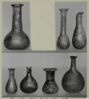 Blown glass vessels with long necks and rounded bodies, shown in two rows on a photo card mount