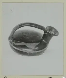 Small black-glazed vessel with a single loop handle and a pale painted animal running around its body.