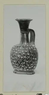 Jug with a flared mouth, one handle and a dotted lattice pattern on the body