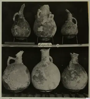 Pottery jugs in two rows on metal stands, from Lapithos Markides T.50