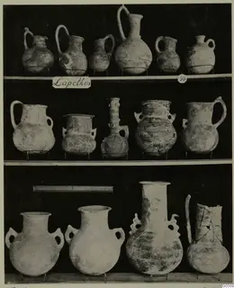 Pottery jugs, jars and flasks on three shelves, with a place label and number 50, from Lapithos Markides Tomb 50