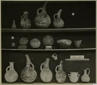 Pottery jugs, jars and bowls from Lapithos Markides, T.203, arranged on three shelves