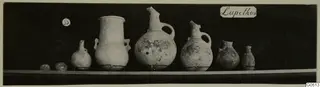 Row of several pottery jars and juglets from Lapithos Markides, T.35, photographed on a shelf.