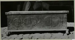 Carved wooden clothes chest, so-called sendudzin, standing on a stone-paved ground