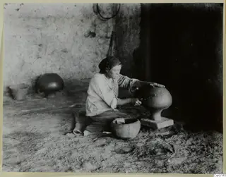 Woman polishing a large clay vessel on a pedestal at Klirou village