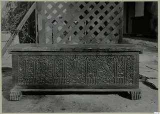 Carved wooden clothes chest, so-called sendudzin, standing on bare ground in front of a lattice screen